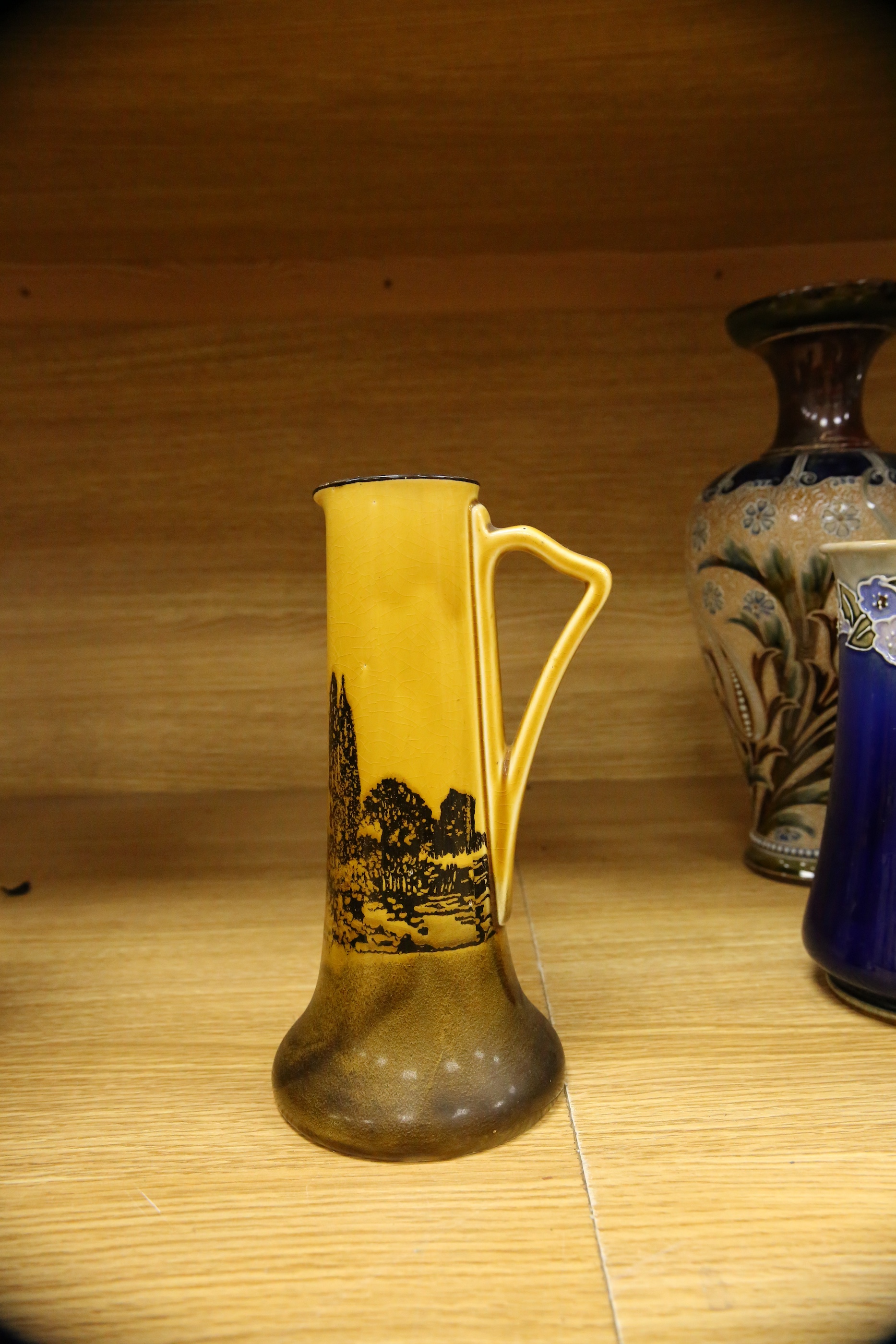 Four Royal Doulton vases and a yellow glazed jug items, tallest vase 34cm high. Condition - some crazing and faults, large vase has damage to lower neck